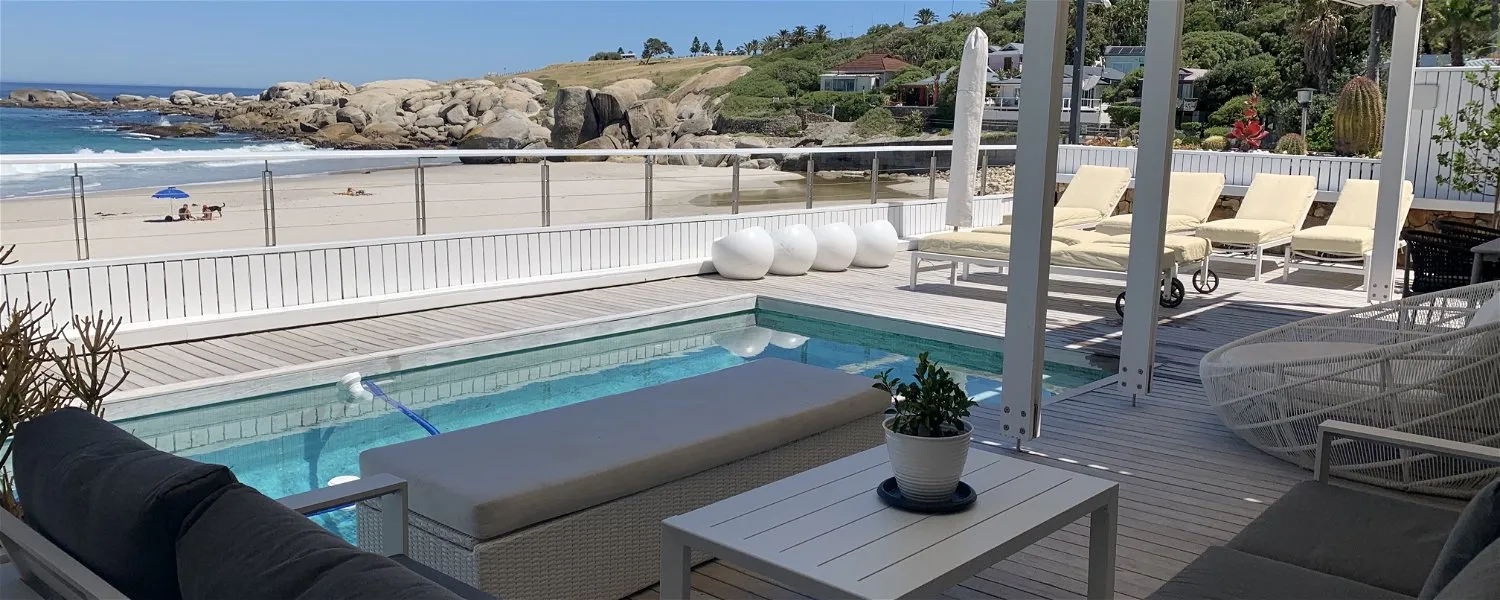 Outdoor patio with pool lounge chairs and ocean view