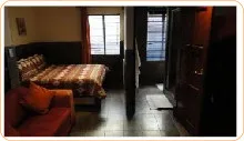 Bedroom with bed sofa and wardrobe featuring wooden accents and barred windows