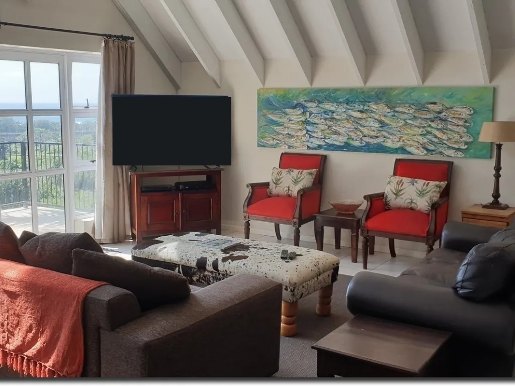 Living room with TV red chairs sofa ottoman and large fish painting