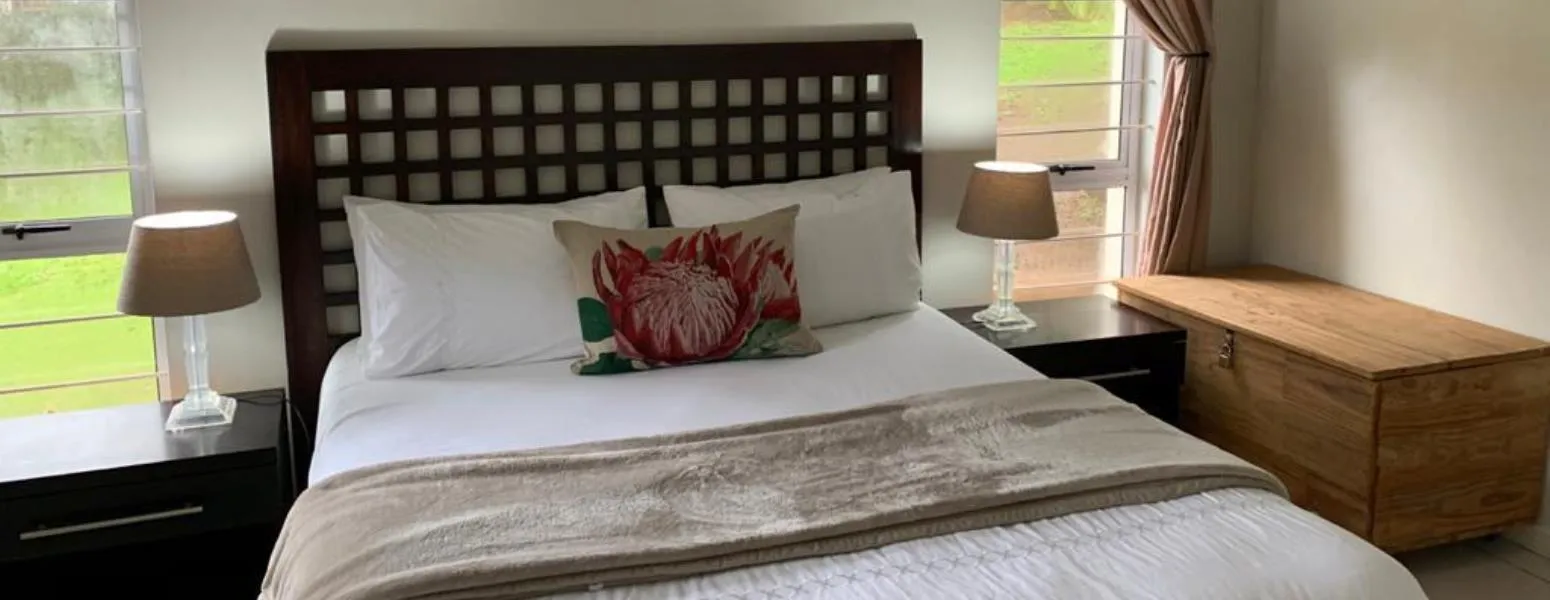 Neat bedroom with a large bed two bedside tables and a wooden chest