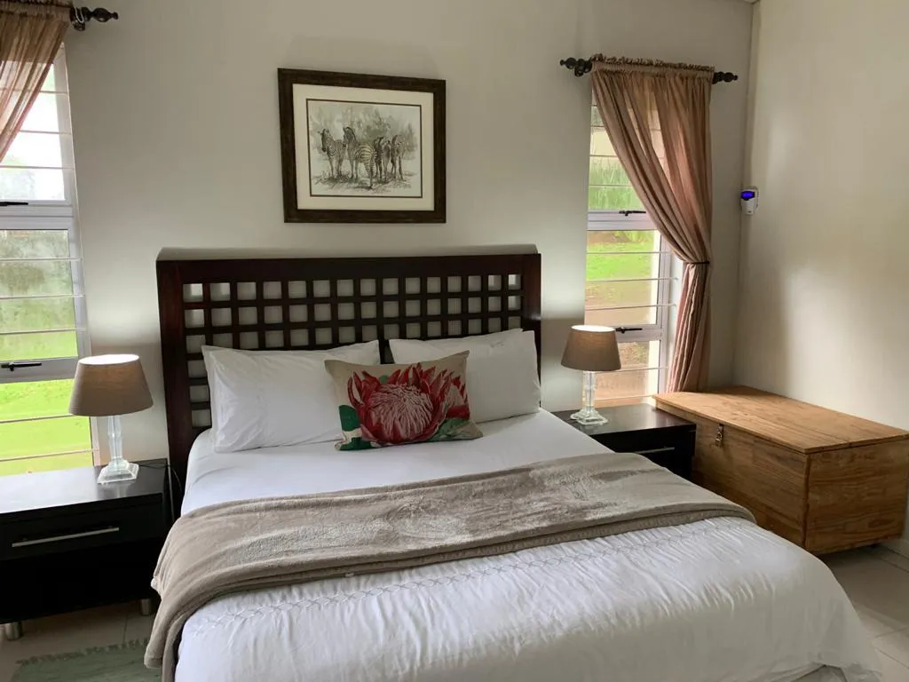 Cozy bedroom with a large bed wooden headboard and bedside tables with lamps