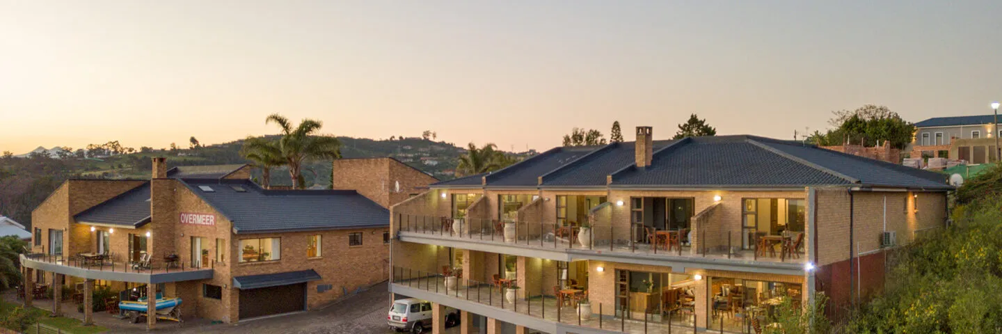 Modern apartment buildings with balconies at sunset surrounded by greenery