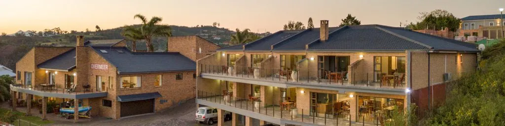 Modern apartment buildings with balconies at sunset surrounded by greenery