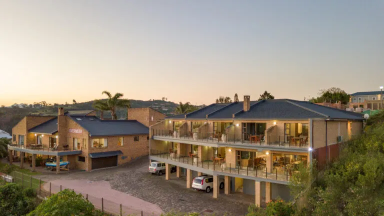 Modern townhouses with balconies on a hillside at sunset