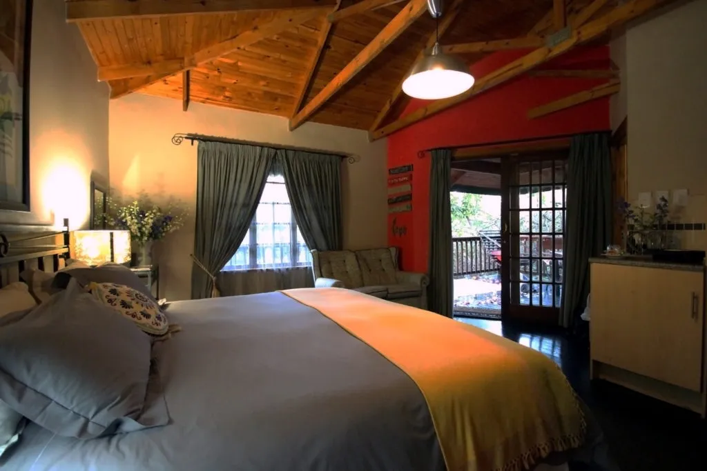 Cozy bedroom with wooden ceiling large bed and open patio doors