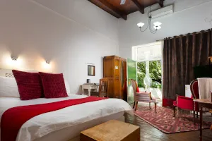 Cozy bedroom with red and white bedding wooden furniture and open window