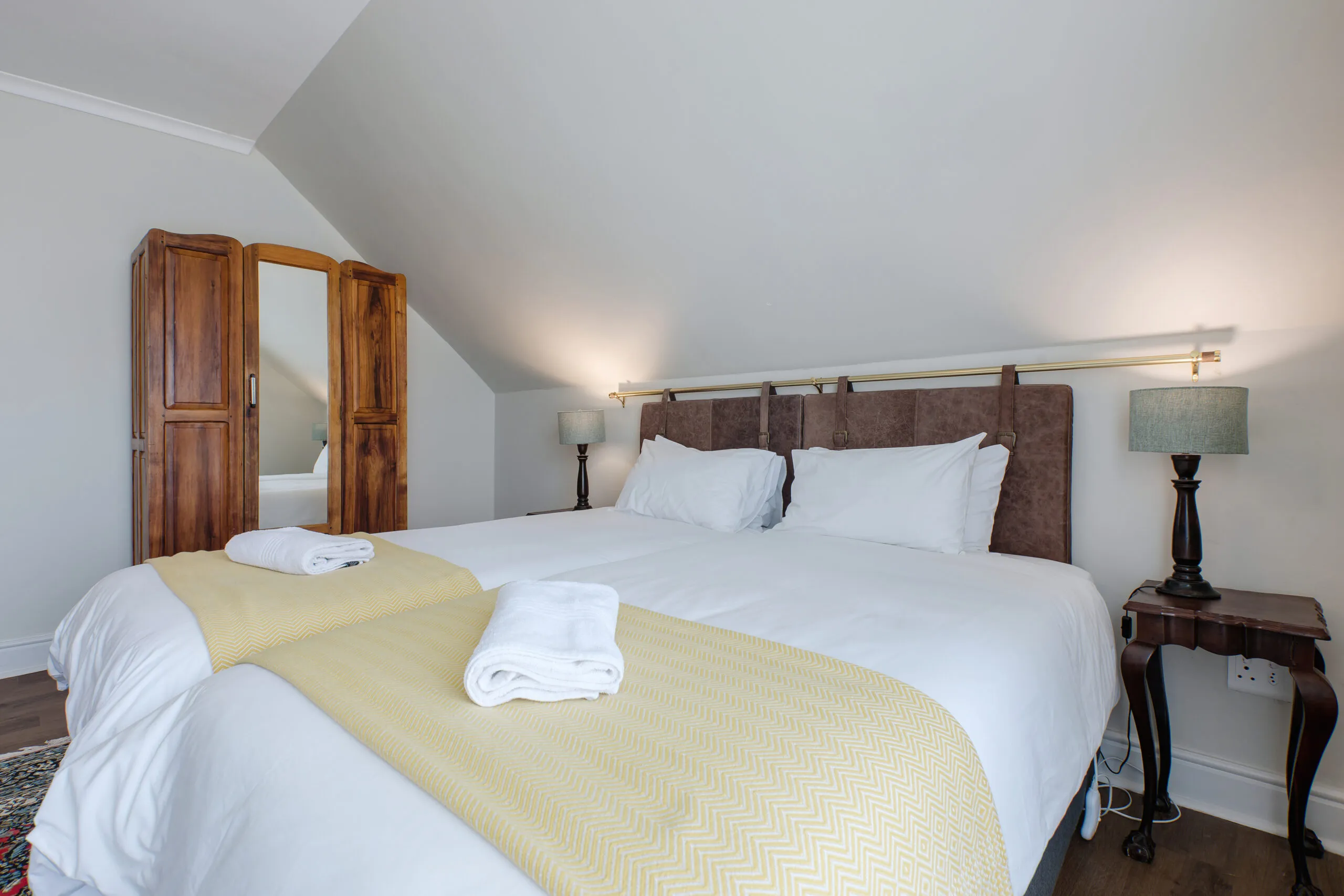Bedroom with large bed wooden wardrobe and bedside tables with lamps