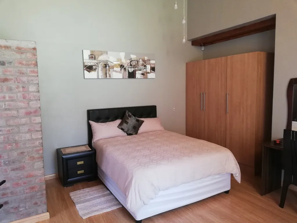 Bedroom with a bed wardrobe and wooden floor featuring modern decor