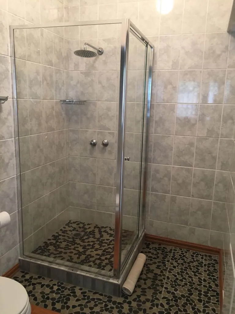Modern shower with glass doors in a tiled bathroom