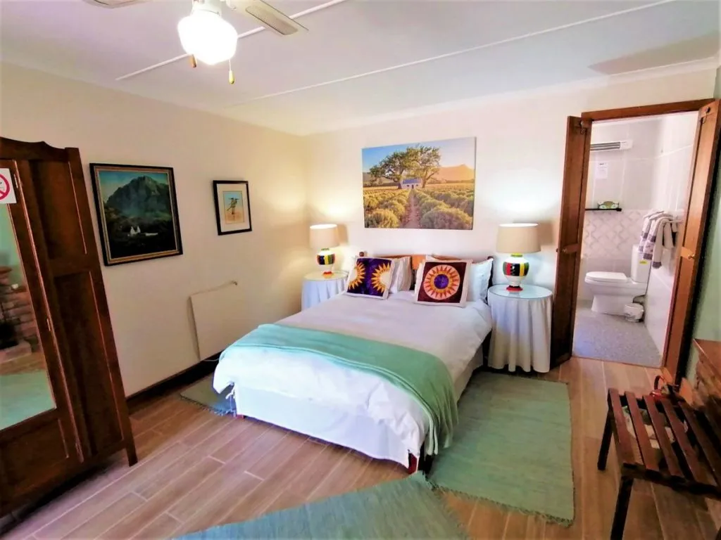 Cozy bedroom with a bed artwork and an open bathroom door