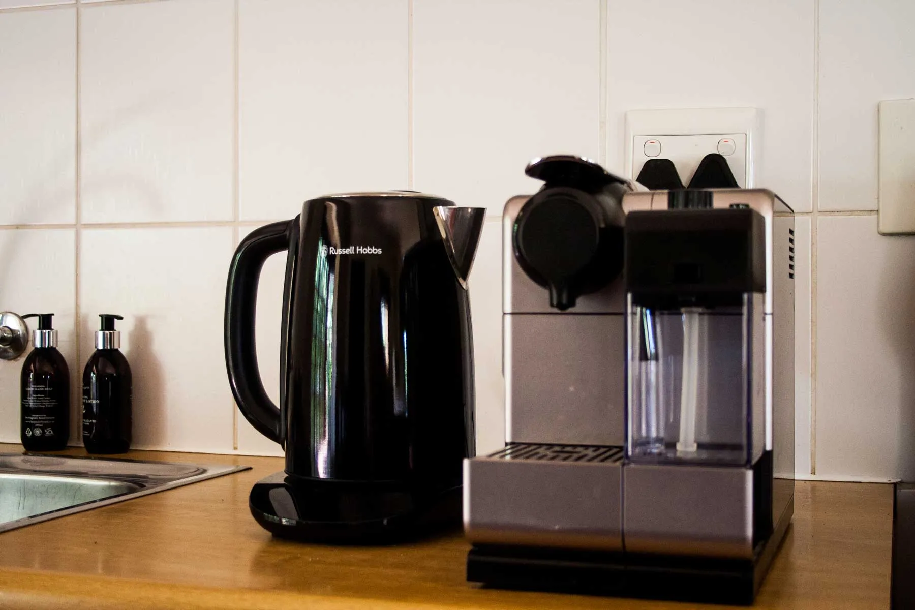 Black kettle and espresso machine on a wooden counter in a kitchen