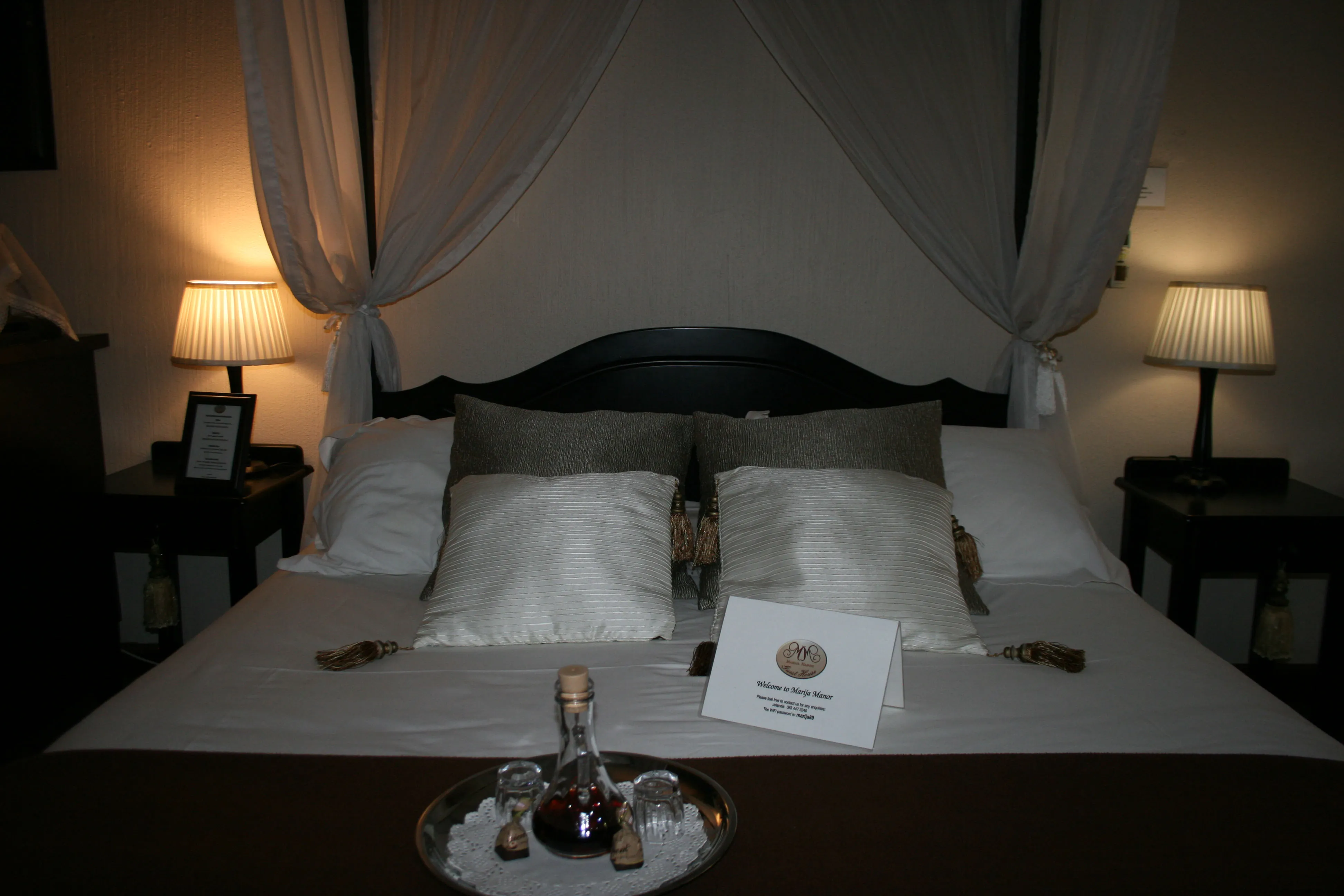 Romantic bedroom setup with canopy bed pillows and bedside lamps