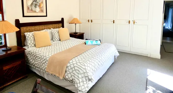 Neat bedroom with a large bed nightstands and white wardrobes