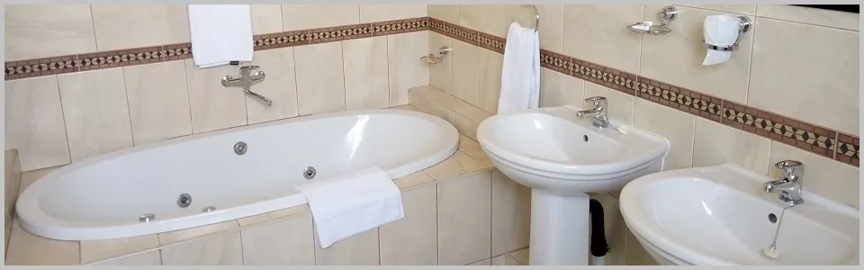 Modern bathroom with a bathtub two sinks and tiled walls