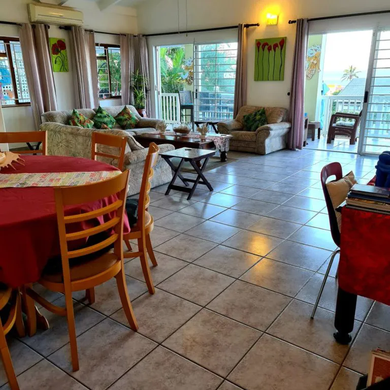 Bright living room with dining table sofas and large sliding glass doors
