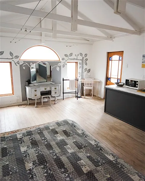 Wooden attic room with vanity chairs microwave and patterned rug