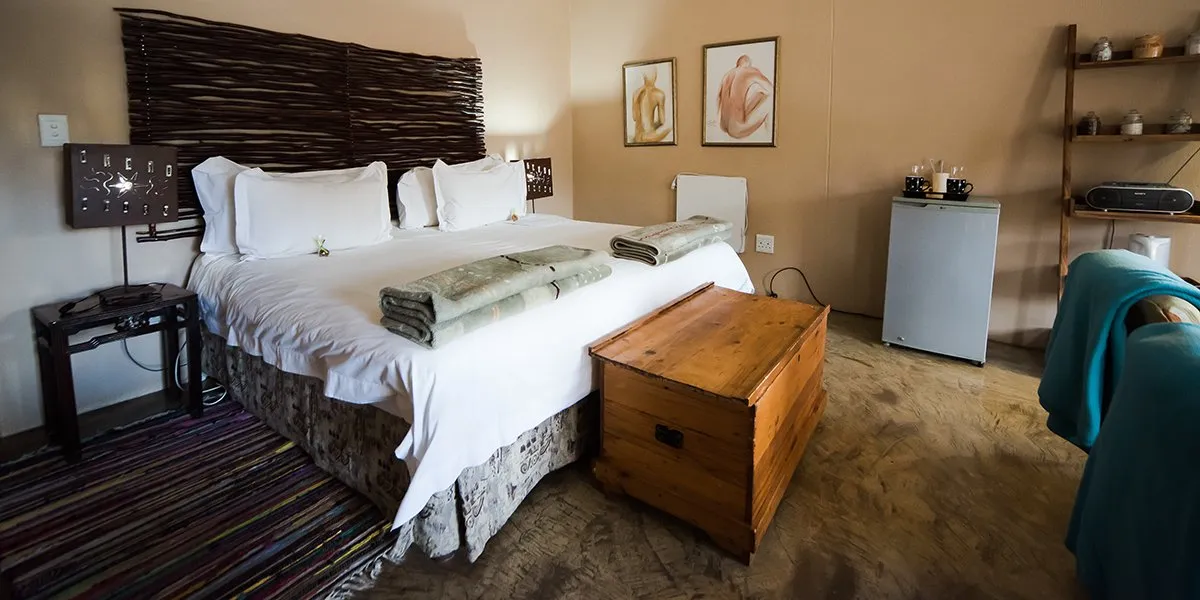 Cozy bedroom with a large bed wooden chest and bedside lamps