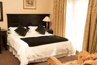 Cozy bedroom with large bed dark headboard and curtains over windows