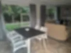 Blurry indoor scene with table chairs and view of greenery outside