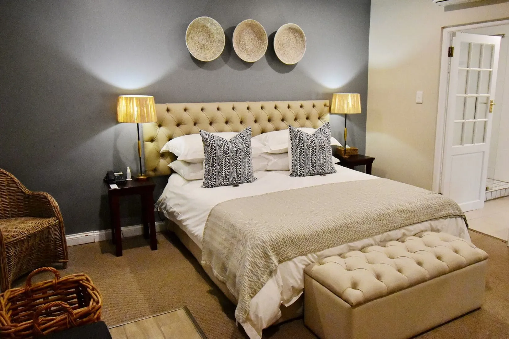 Cozy bedroom with a large bed two lamps and woven wall decorations
