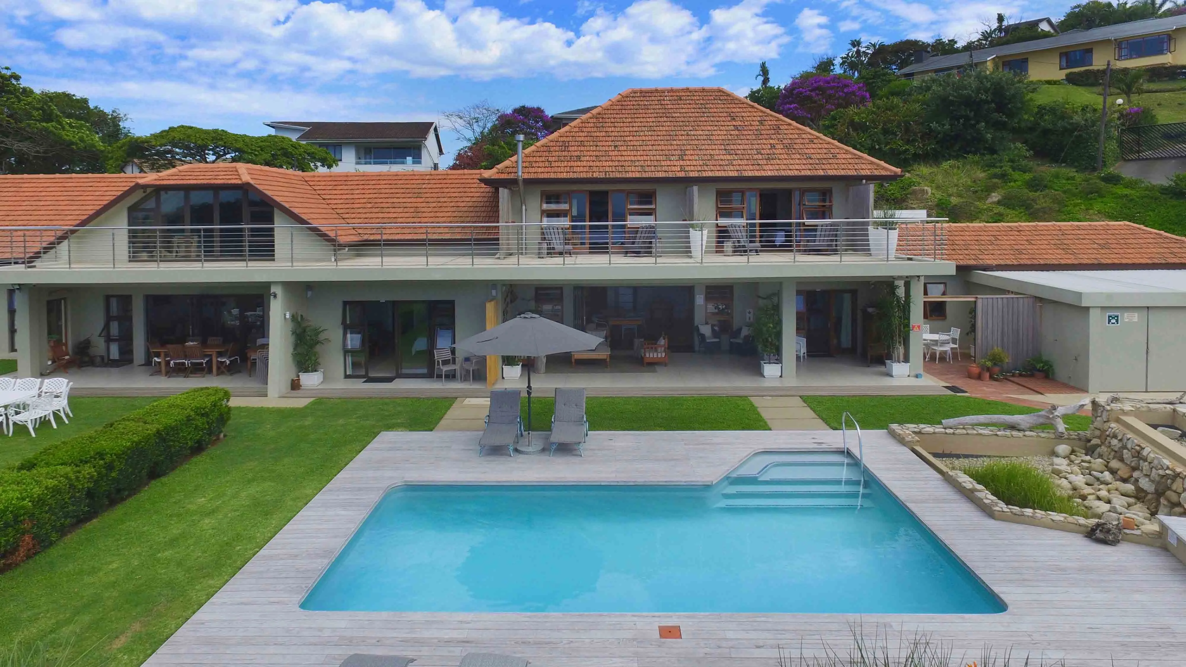 Large house with redtiled roof swimming pool and garden area