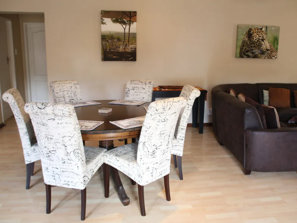 Dining area with round table six chairs and adjacent living room with sofa