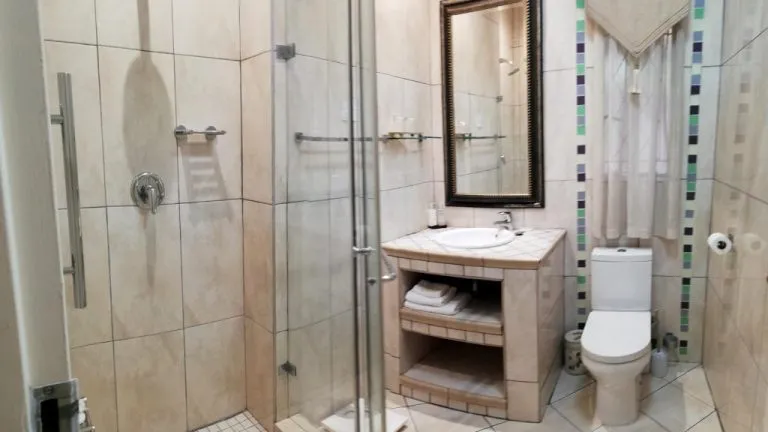 Small bathroom with shower sink toilet and tiled walls