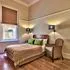 Cozy bedroom with wooden floor bed and armchair under warm lighting