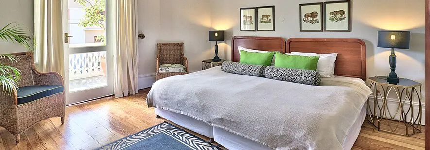 Cozy bedroom with large bed wooden floor and balcony view
