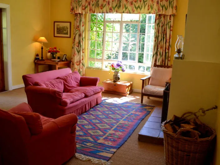 Cozy living room with red sofas floral curtains and large windows