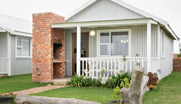 Small house with a brick chimney and a garden in front