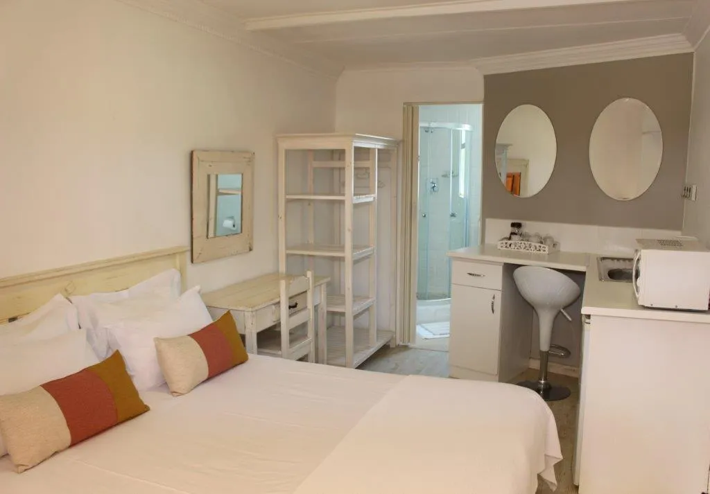 Bedroom with white furniture double bed and attached bathroom