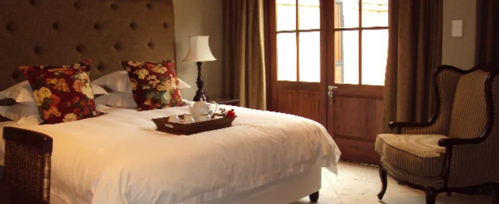 Cozy bedroom with a large bed floral pillows and a tray on the bed