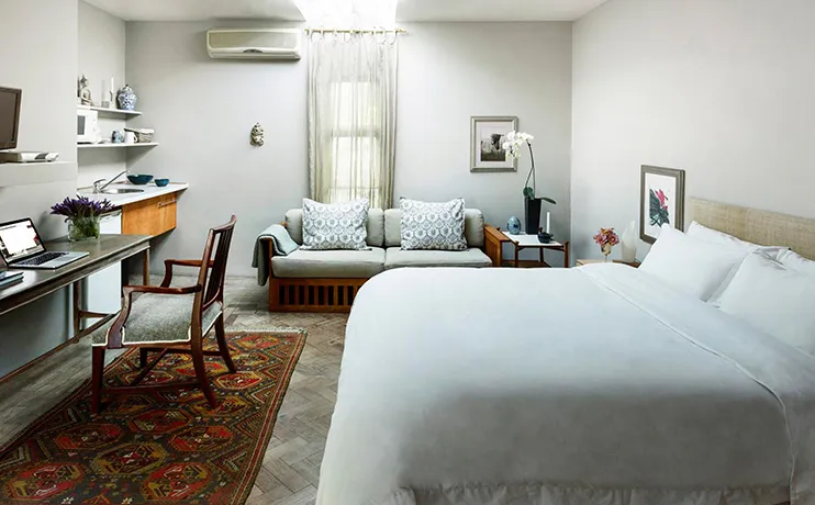 Cozy hotel room with bed sofa desk and decorative elements