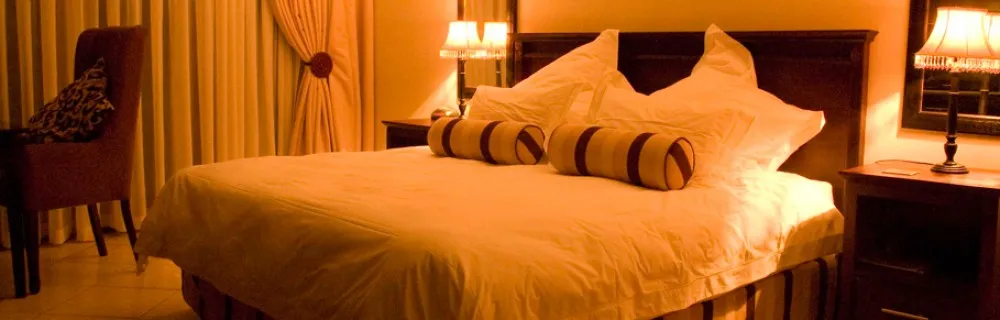 Cozy bedroom with a large bed pillows and bedside lamps warmly lit