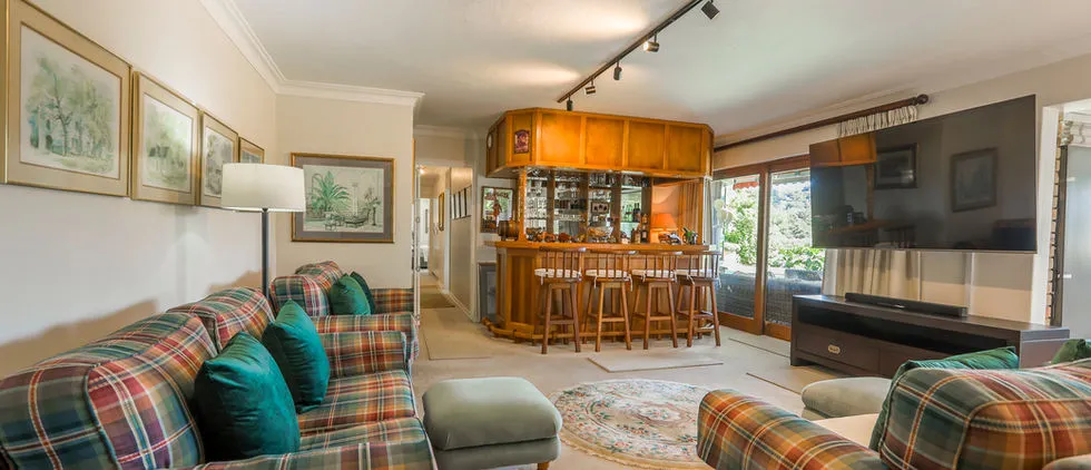 Cozy living room with plaid furniture bar area and large TV