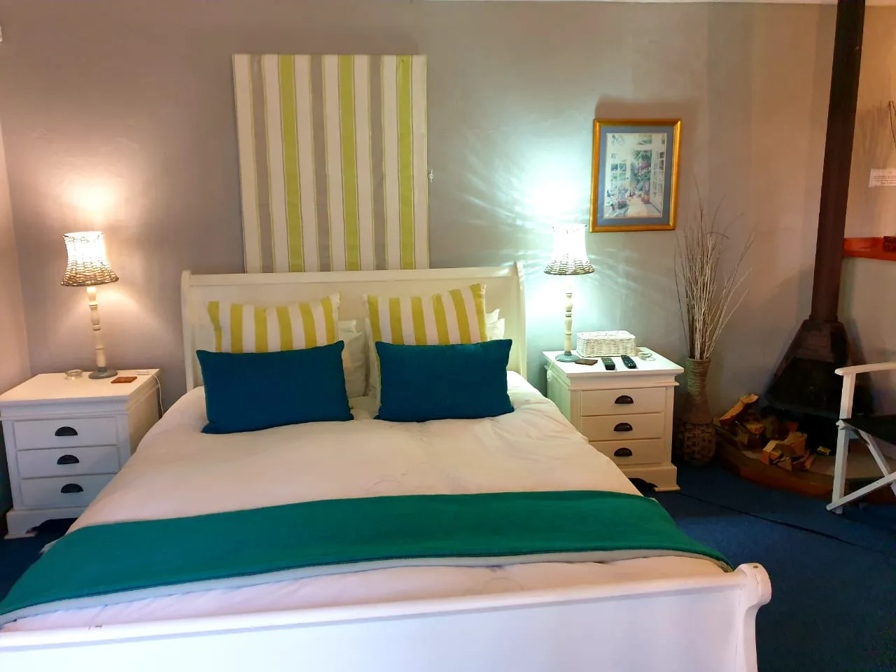 Cozy bedroom with white furniture blue bedding and a fireplace