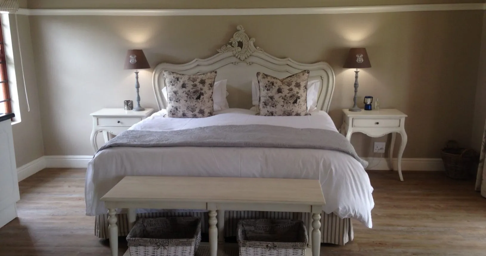 Elegant bedroom with a large bed bedside tables and a bench
