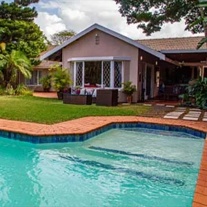 House with a swimming pool and garden furniture in a lush green setting