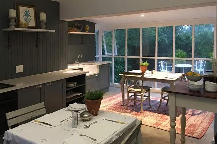 Kitchen with dining area large windows and tables set for a meal