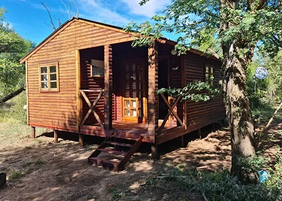 Wooden cabin with porch and steps in a natural setting