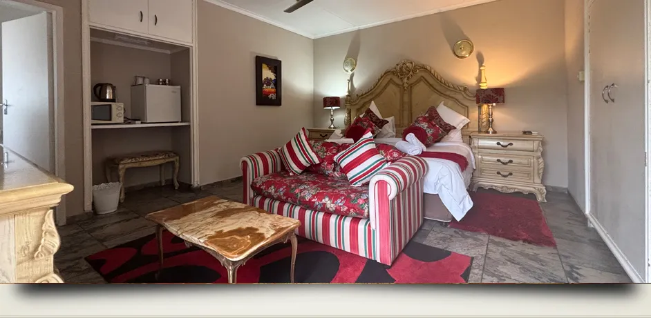 Cozy bedroom with a bed sofa and wooden furniture on a patterned rug