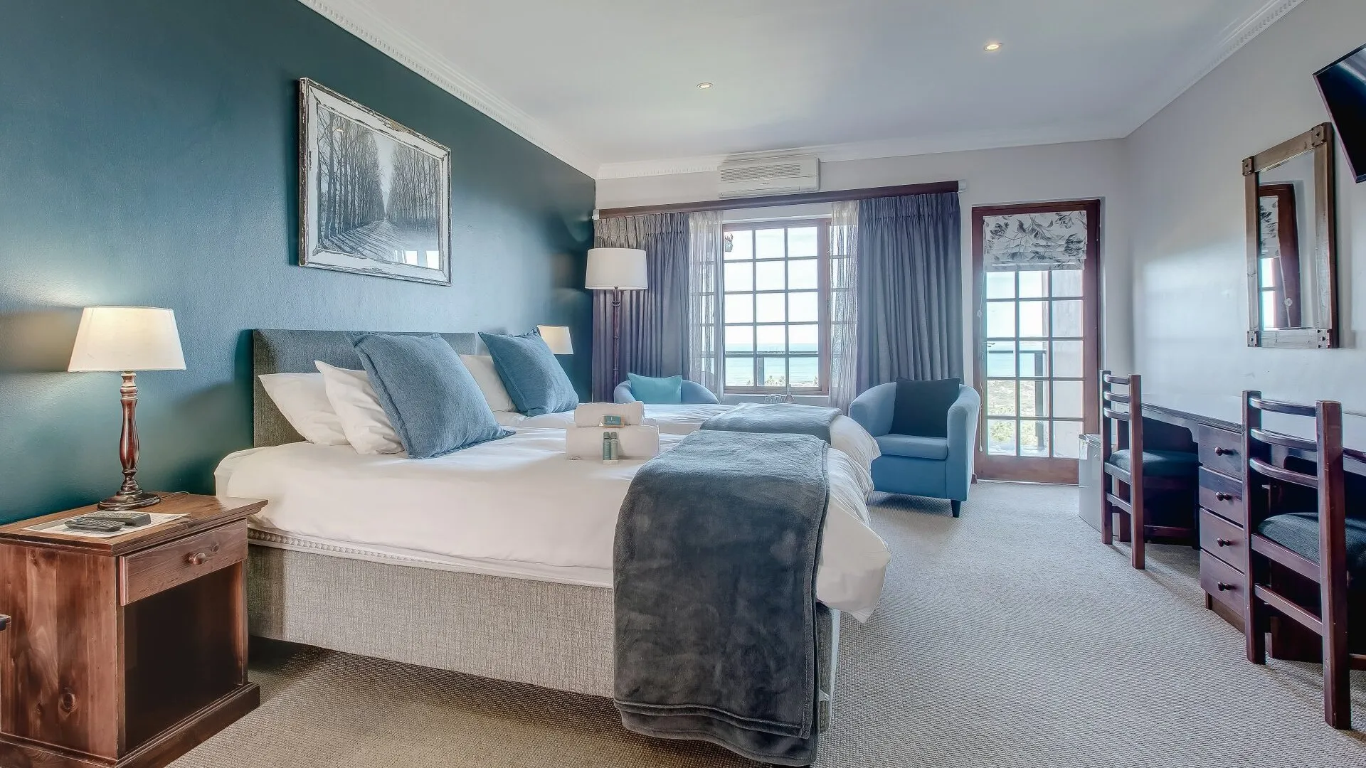 Modern hotel room with large bed armchair and large window