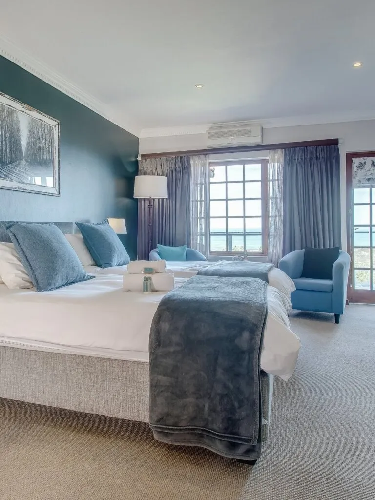 Bedroom with large bed blue accents and window view of the outdoors