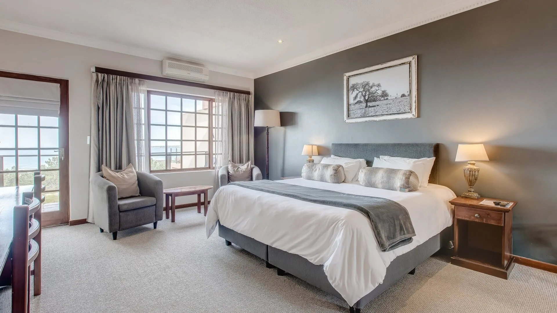 Modern bedroom with large bed seating area and large windows