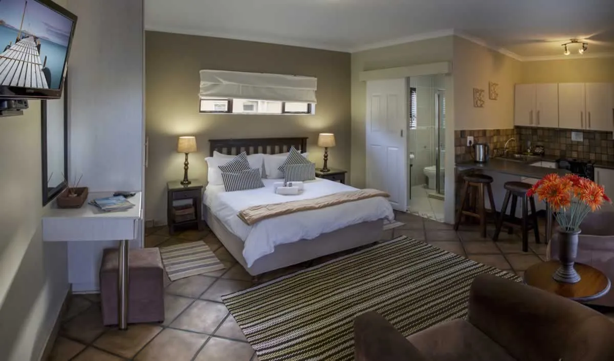 Cozy studio apartment with bed kitchenette and seating area