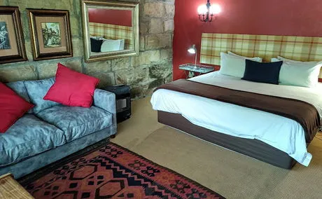 Cozy bedroom with a bed sofa stone wall and framed pictures