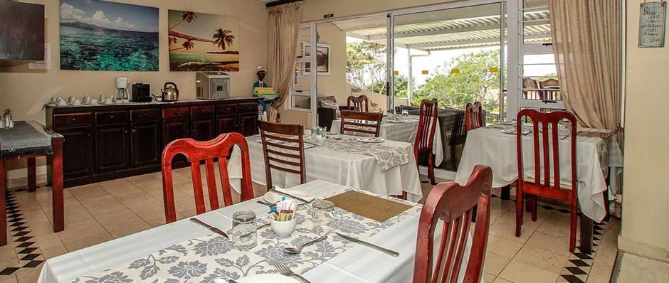 Dining area with tables chairs and tropicalthemed wall art