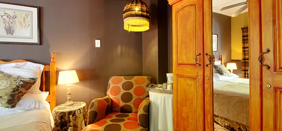 Cozy bedroom with polka dot chair wooden wardrobe and warm lighting