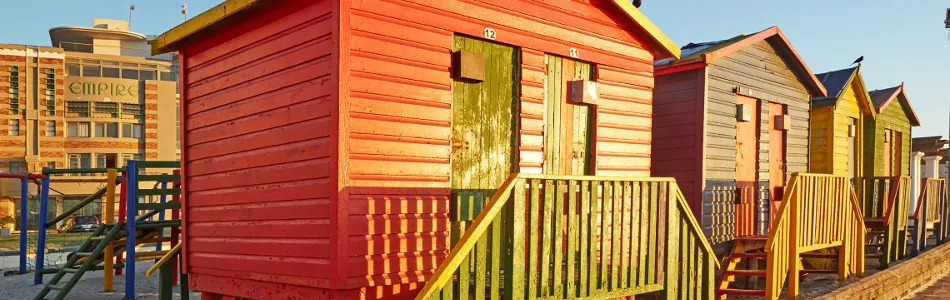 Colorful beach huts with stairs in a row on a sunny day